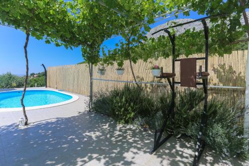 a garden with a pergola and a swimming pool at Holiday Home Rupotina with a large yard, pool and a beautiful view in Solin