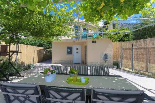 a table and chairs in front of a house at Holiday Home Rupotina with a large yard, pool and a beautiful view in Solin
