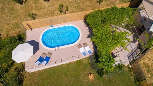 an overhead view of a swimming pool with chairs and umbrellas at Holiday Home Rupotina with a large yard, pool and a beautiful view in Solin