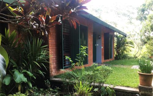 a brick house in the middle of a garden at ADRI CHEMBRA in Meppādi