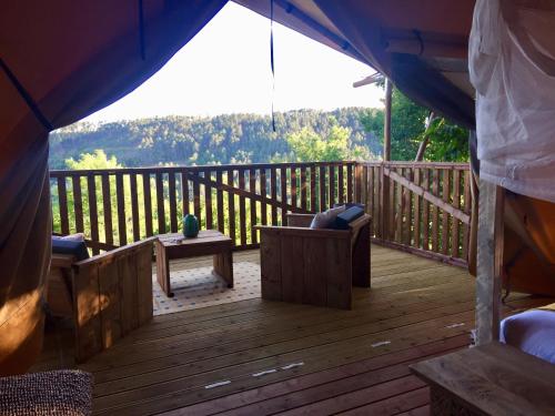a wooden deck with a view of the mountains at Domaine de Chalvêches Hôtel SPA 4* in Faugères