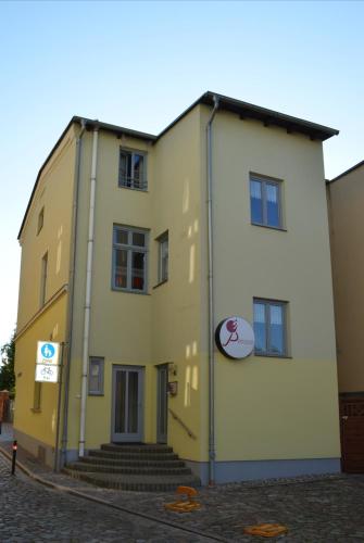 a yellow and white building on the side of a street at Pension am Pferdemarkt in Güstrow