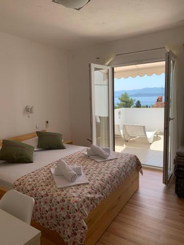 a bedroom with a bed with a view of a patio at Kos Apartments in Bol