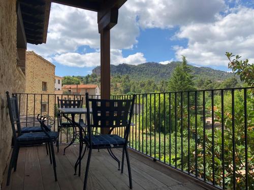 two chairs and a table on a porch with a view at Casa Morató in Beceite
