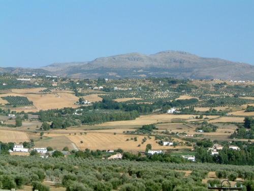 a small town in a field with mountains in the background at Hotel Boutique Molino del Arco in Ronda