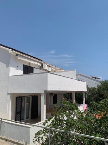 a white house with a fence in front of it at Kos Apartments in Bol