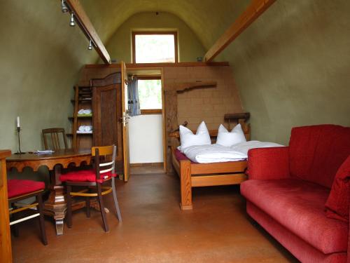 a bedroom with a bed and a couch and a table at Gästehaus am Wangeliner Garten in Wangelin