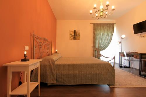 a bedroom with a bed and a table and a chandelier at San Paterno B&B in Rapolano Terme