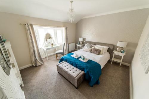 a bedroom with a bed and a chair and a window at Hallam Lodge in Nelson