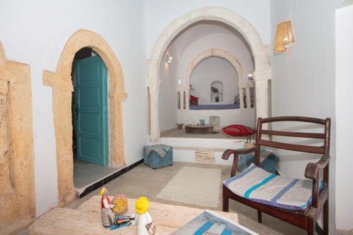 a living room with two arched doors and a table at Dar Tenast in Houmt Souk