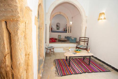 a living room with a table and a couch at Dar Tenast in Houmt Souk