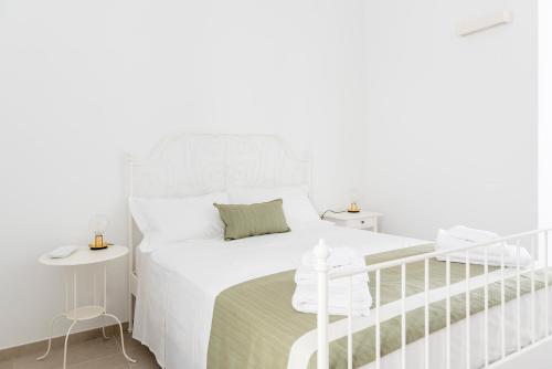a white bedroom with a white bed and a staircase at BnB FICO in Lecce