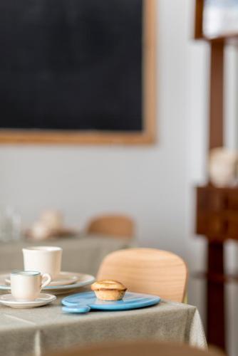 a table with two cups and a plate with muffins on it at BnB FICO in Lecce
