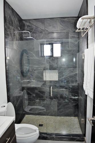 a bathroom with a glass shower with a toilet at Casita de Moana in Puerto Peñasco