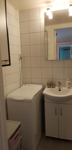 Un baño con lavabo, inodoro y espejo. en Holiday house in Lofoten, en Kabelvåg