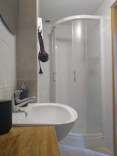 a bathroom with a shower and a white tub at Gierszówka Smak&Relaks in Gietrzwałd