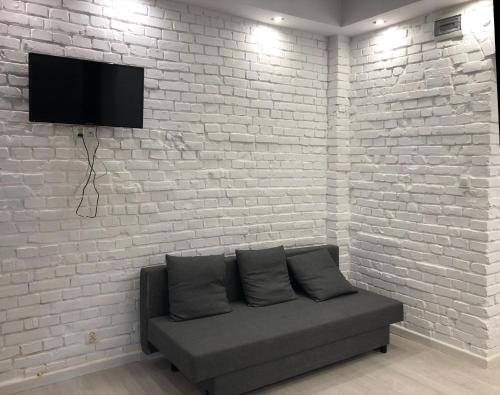 a living room with a couch against a brick wall at Aparthotel 11 in Kwidzyn