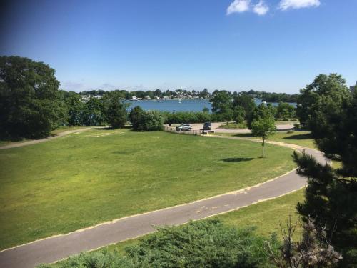 a view of a park with a road and a lake at Arbor Inn Motor Lodge - Weymouth in Weymouth