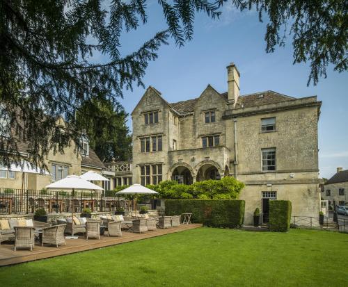 an exterior view of a building with chairs and umbrellas at The Painswick in Painswick
