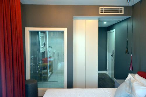 a bedroom with a glass door leading into a room at Ferush Boutique Hotel in Urla