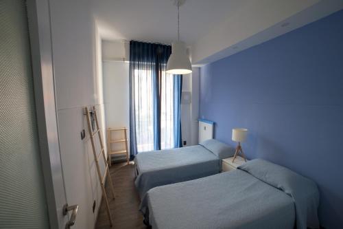 Habitación azul con 2 camas y ventana en Il Grecale, en Recco