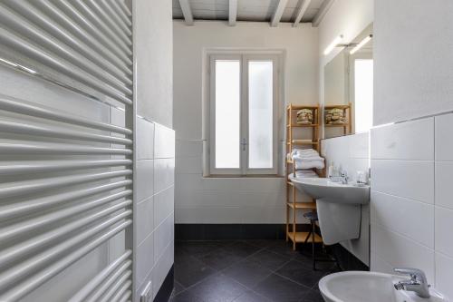 a white bathroom with a sink and a mirror at Cedro Apartment - Smart Holiday in Mantova