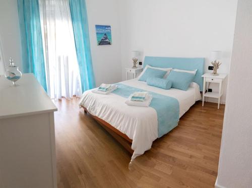 ein Schlafzimmer mit einem großen Bett mit blauen Kissen in der Unterkunft Bay View Apartment in Porto Torres