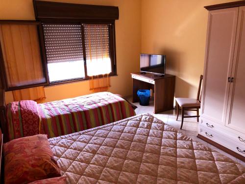 sypialnia z łóżkiem, biurkiem i telewizorem w obiekcie B&B City Bar w mieście Uta