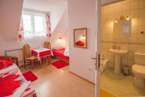 a room with a bathroom with a bed and a sink at Pensjonat U Bogusi in Berezka