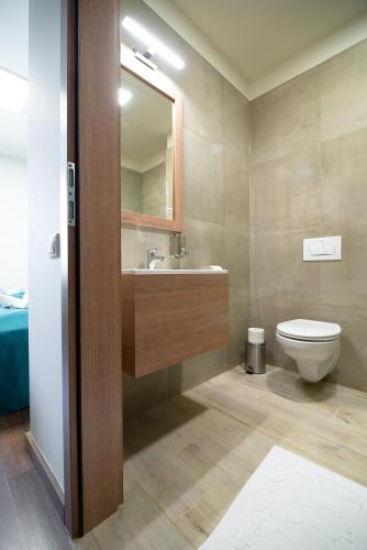 a bathroom with a toilet and a sink and a mirror at Hotel Szeghalom in Szeghalom