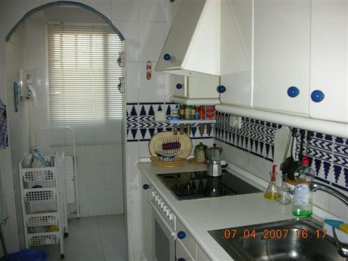 a small kitchen with white cabinets and a sink at Dúplex La Manga del Mar Menor Pedruchillo in La Manga del Mar Menor