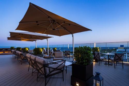 a deck with tables and chairs and umbrellas at Hyatt Regency Tokyo Bay in Urayasu