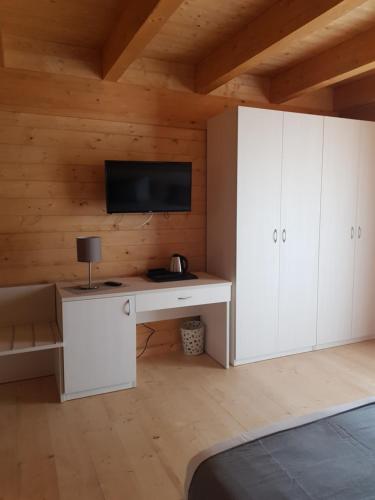 a bedroom with a desk and a tv on a wall at Lorica Suite Lago in Lorica