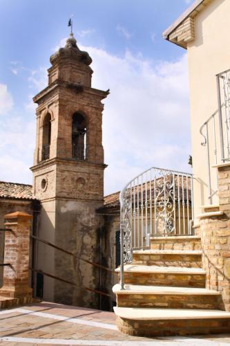 a building with a clock tower and stairs at Agriturismo Pozzuolo in Serrungarina