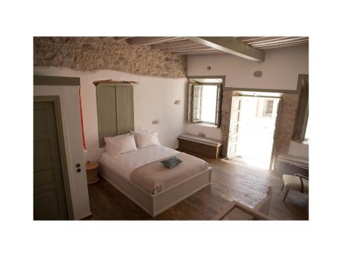 a bedroom with a bed in the middle of a room at Latmos 1860 in Skala