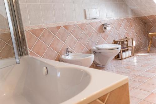 a bathroom with a toilet and a tub and a sink at Villa Anna Bad Goisern am Hallstättersee in Bad Goisern