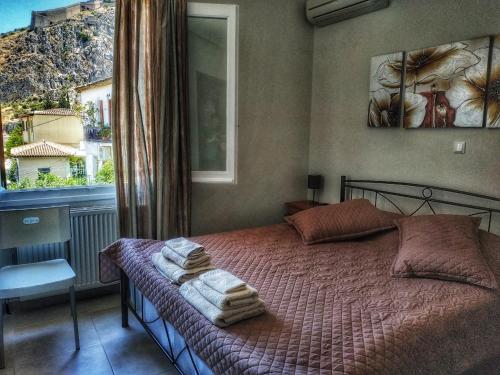 um quarto com uma cama com toalhas em Aggeliki Apartments em Nafplio
