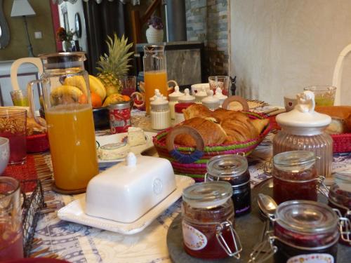 a table topped with food and orange juice and bread at Montagne attitude in Jausiers