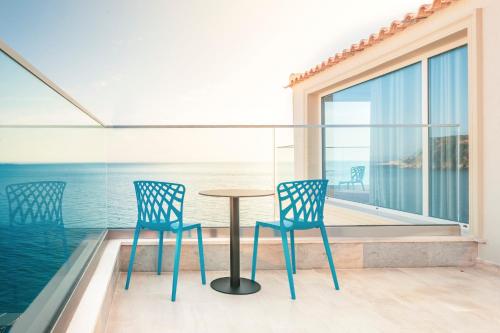 - un balcon avec deux chaises et une table donnant sur l'océan dans l'établissement ARXONTIKO, à Himarë