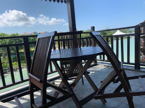 a wooden bench sitting on top of a balcony at SEA VILLA LANGKAWI LAGOON in Pantai Cenang