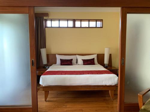 a bedroom with a large bed with red pillows at SEA VILLA LANGKAWI LAGOON in Pantai Cenang