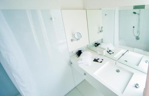 Baño blanco con lavabo y espejo en Hotel zum Hofmaler en Potsdam