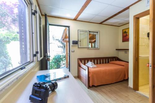 una macchina fotografica in una stanza con un letto e una finestra di Villaggio Tramonto a Capo Vaticano