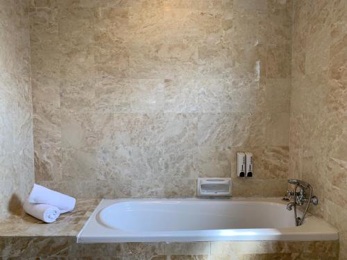 a bath tub in a bathroom with a sink at SEA VILLA LANGKAWI LAGOON in Pantai Cenang