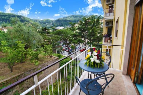 Un balcón con una mesa con flores. en Hotel Savoia Sorrento, en Sorrento
