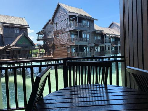 a wooden bench on a balcony with a house at SEA VILLA LANGKAWI LAGOON in Pantai Cenang