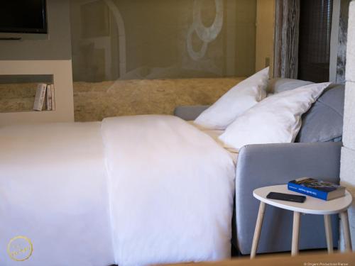 a white couch with pillows and a side table at Les Garrigues de la Vallée des Baux in Paradou