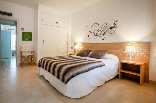 um quarto com uma cama grande e uma mesa com um candeeiro em Apartamento a pie de playa, climatizado y parking em Roses