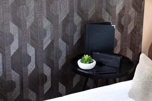 a table with a plant on it next to a wall at Best Western Plus Hotel les Rives du Ter in Larmor-Plage