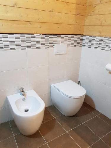a bathroom with a white toilet and a sink at Lorica Suite Lago in Lorica